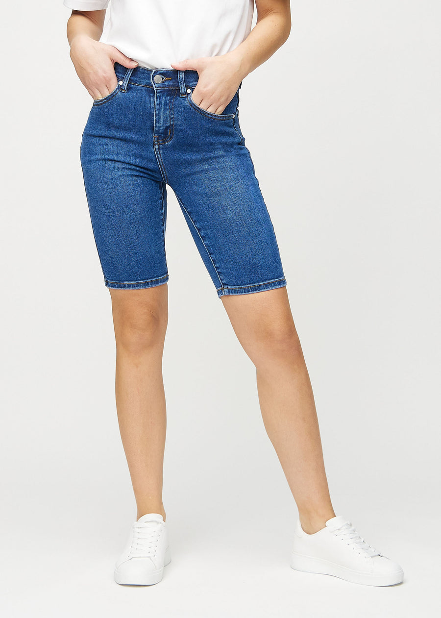 Mörk denim skinny middle shorts, modellnamn Oceans, som sitter tätt över låret och slutar precis ovanför knät, framifrån.