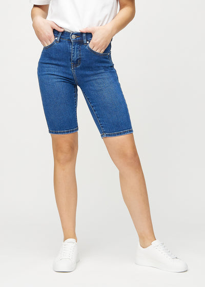 Mörk denim skinny middle shorts, modellnamn Oceans, som sitter tätt över låret och slutar precis ovanför knät, framifrån.