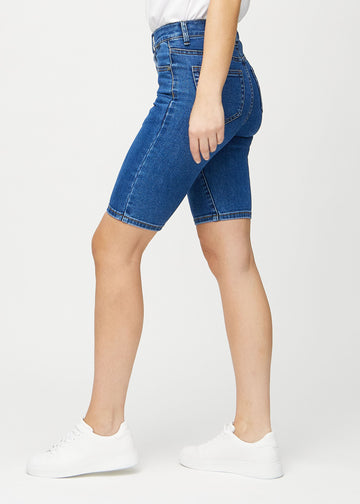 Mörk denim skinny middle shorts sedda från sidan på modell.