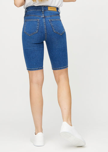 Mörk denim skinny middle shorts sedda bakifrån, så att man kan se hela produkten.