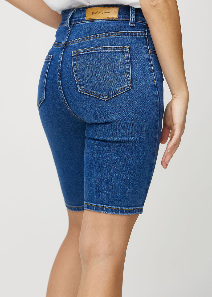 Mörk denim skinny middle shorts sedda bakifrån på nära håll för att visa detaljer.