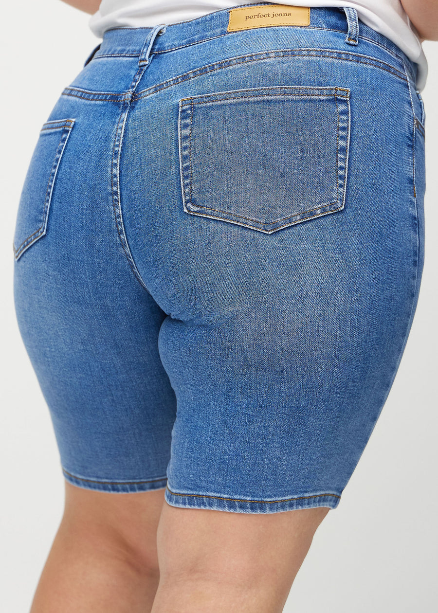 Denim skinny middle shorts sedda bakifrån i närbild på en plus size-modell för att visa detaljer.