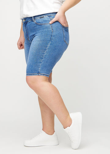 Denim skinny middle shorts sedda från sidan på en plus size-modell.