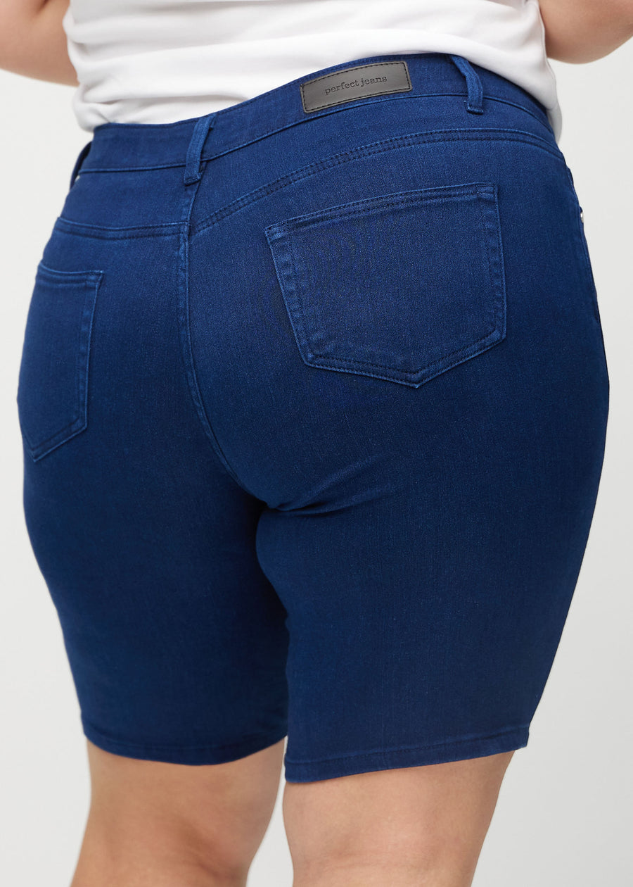 Mörkblå skinny middle shorts sedda bakifrån i närbild på en plus-size-modell för att visa detaljer.