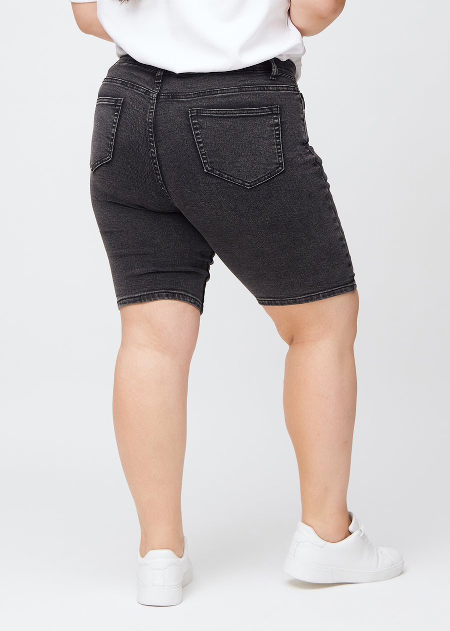 Kvinna i mörkgrå denimshorts sedd bakifrån
