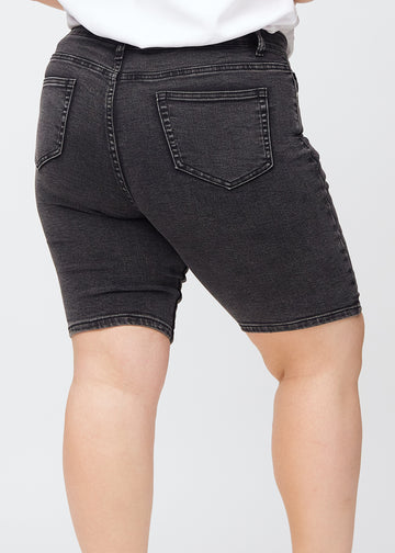 Mörkgrå denim skinny middle shorts sedda bakifrån i närbild på en plus size-modell för att visa detaljer.