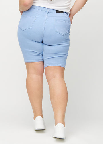 Ljusblå skinny middle shorts sedda bakifrån på en plus-size-modell, så att man kan se hela produkten.