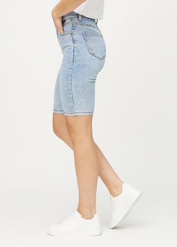 Ljus denim skinny middle shorts sedda från sidan på modell.