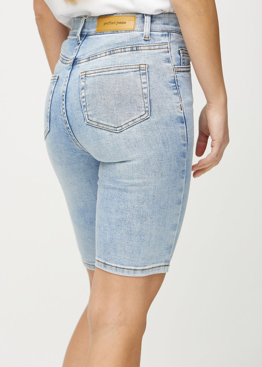 Ljus denim skinny middle shorts sedda bakifrån i närbild för att visa detaljer.