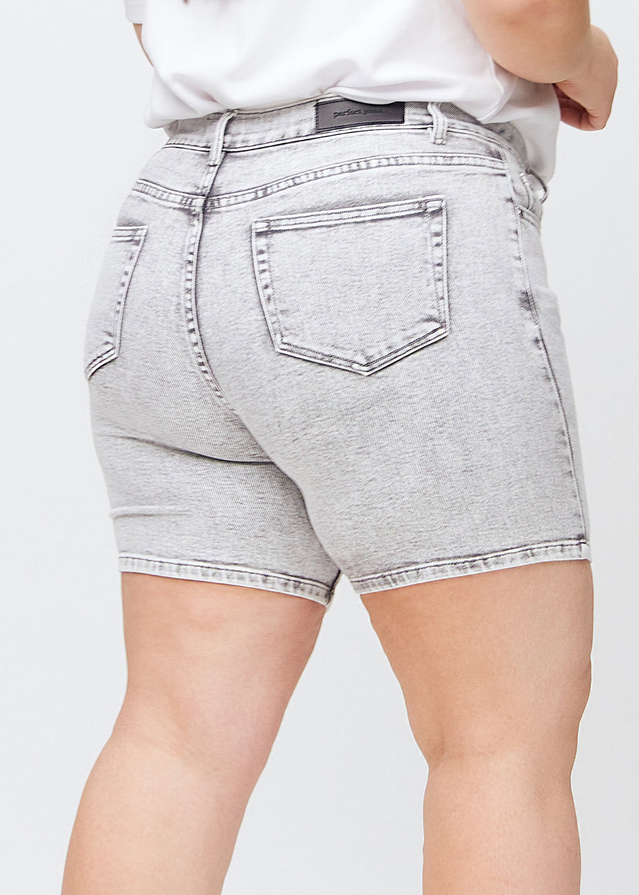 kvinna i ljusgrå denimshorts