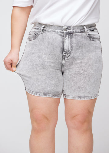 Plus size-modellen sträcker shortsen vid låret för att visa stretch.
