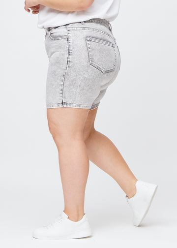 Ljusgrå denim skinny short shorts sedda från sidan på en plus size-modell.