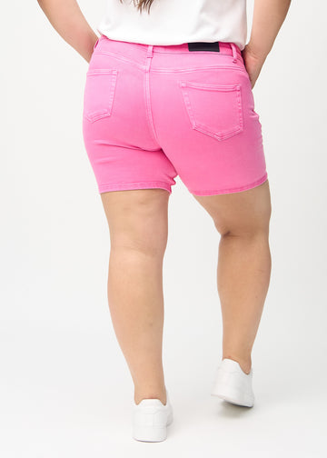 Ljusrosa skinny short shorts sedda bakifrån på en plus-size-modell, så att man kan se hela produkten.