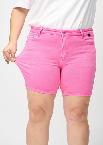 Plus-size-modellen drar ut shortsen vid låret för att visa stretch.