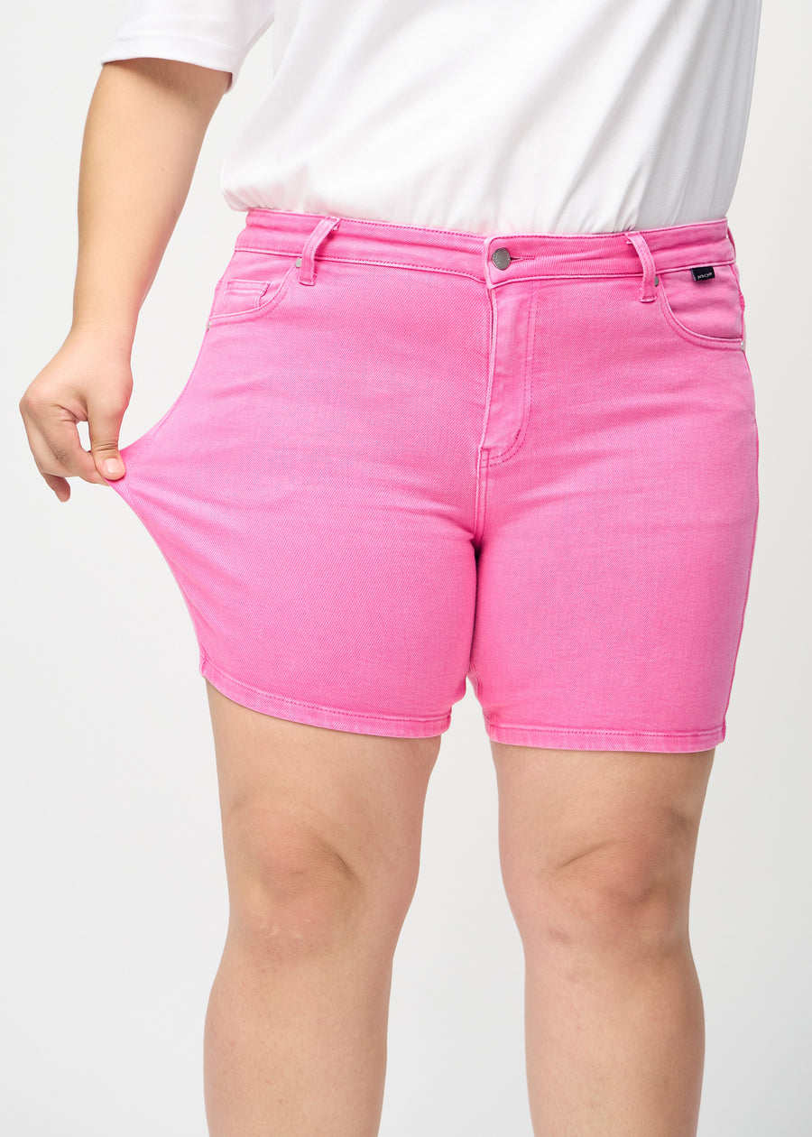 Plus-size-modellen drar ut shortsen vid låret för att visa stretch.