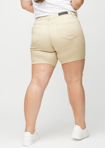 Beige skinny short shorts sedda bakifrån på en plus-size-modell, så att man kan se hela produkten.