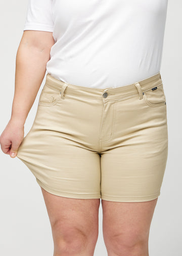 Plus-size-modellen sträcker shortsen vid låret för att visa stretch.