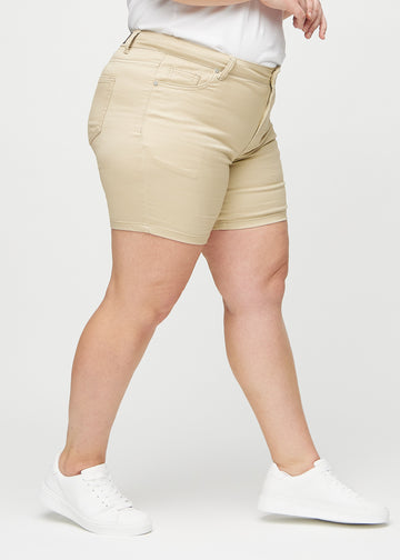 Beige skinny short shorts sedda från sidan på en plus-size-modell.