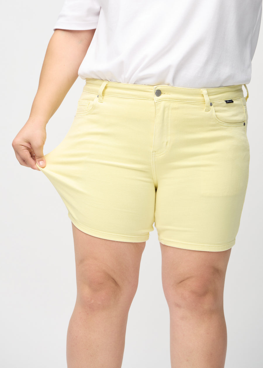 Plus-size-modellen sträcker ut shortsen vid låret för att visa stretch.