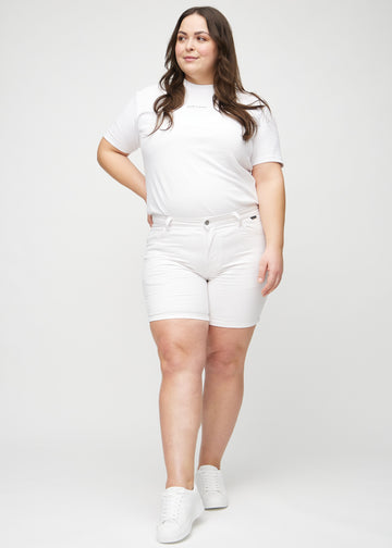 Helbild av en plus size-modell i vita skinny short shorts.