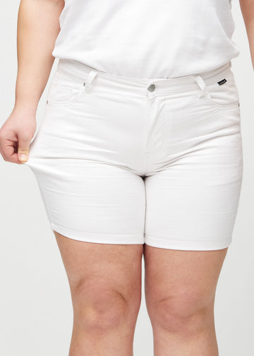 Plus size-modellen drar ut shortsen vid låret för att visa stretch.