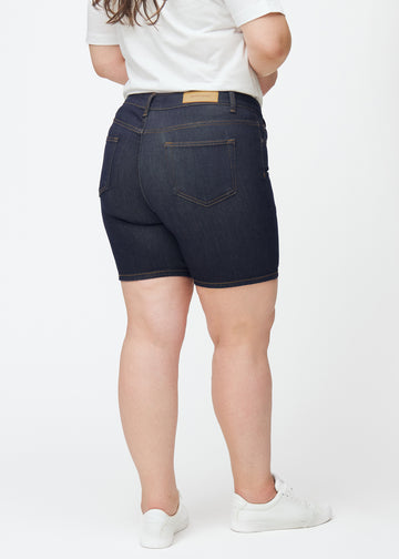 Mörkblå denimshorts för dam i färgen Midnights sett bakifrån på plus-size modell, där längden till mitten av låret syns.