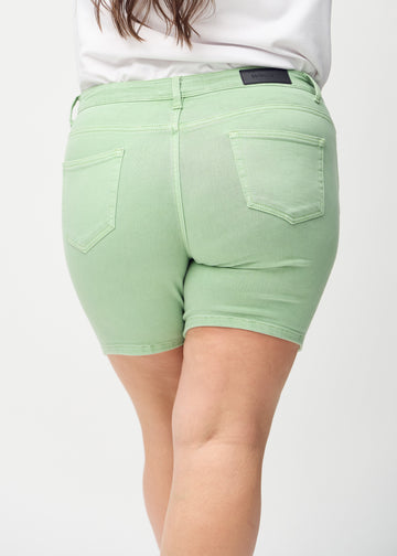 Ljusgröna skinny short shorts sedda bakifrån i närbild på en plus-size-modell för att visa detaljer.