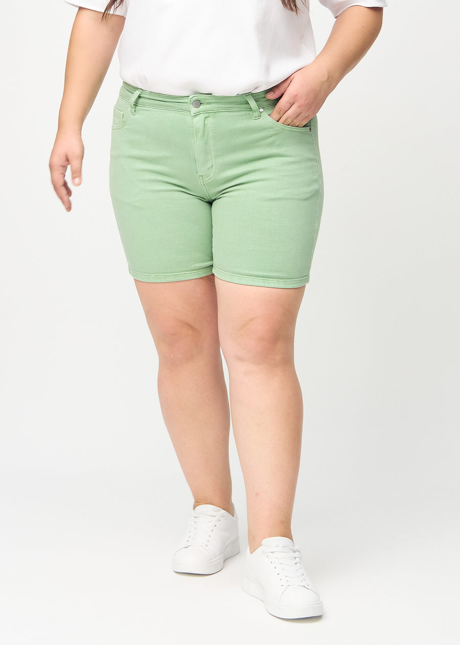 Ljusgröna skinny short shorts, modellnamn Mints, som sitter tight och slutar mitt på låret på en plus-size-modell, sedda framifrån.