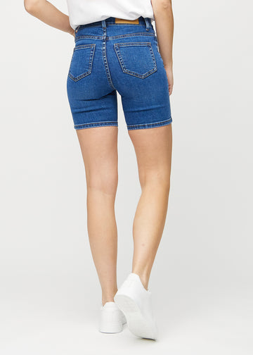 Mörk denim skinny short shorts sedda bakifrån, så att man kan se hela produkten.