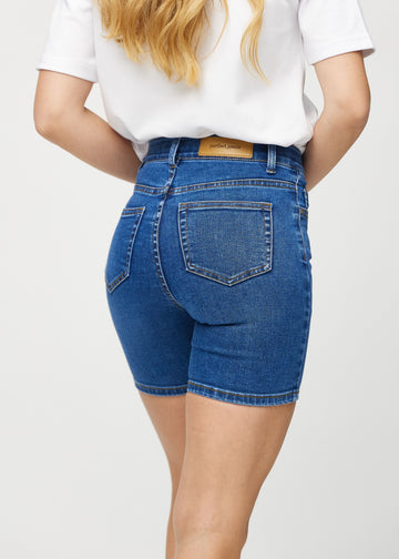Mörk denim skinny short shorts sedda bakifrån i närbild för att visa detaljer.