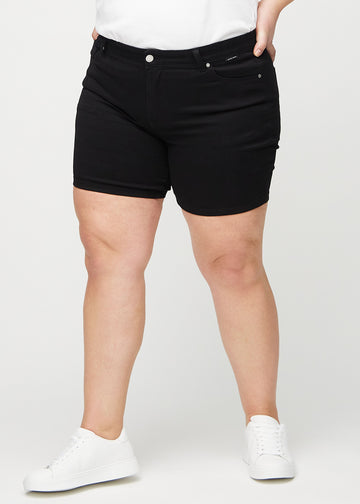 Svarta skinny short shorts, modellnamn Ravens, som sitter tight och slutar mitt på låret på en plus size-modell, sedda framifrån.
