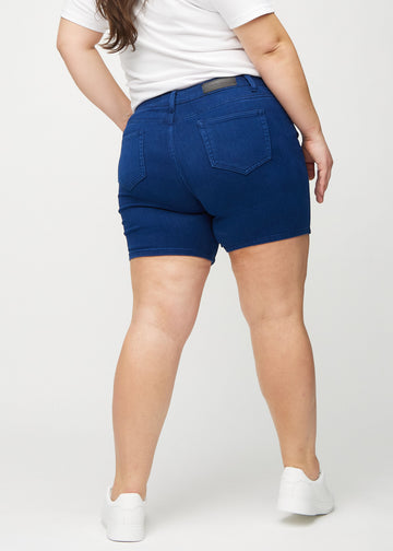 Mörkblå skinny short shorts sedda bakifrån på en plus size-modell, så att man kan se hela produkten.