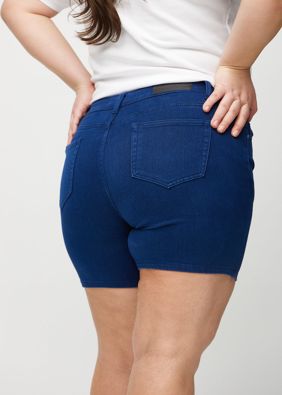 Mörkblå skinny short shorts sedda bakifrån i närbild på en plus size-modell för att visa detaljer.