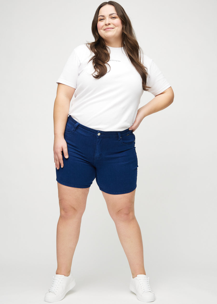Helbild av en plus size-modell i mörkblå skinny short shorts.