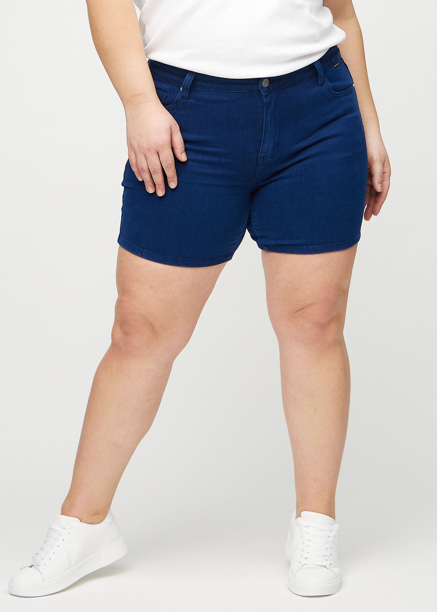 Mörkblå skinny short shorts, modellnamn Royals, som sitter tight och slutar mitt på låret på en plus size-modell, framifrån.