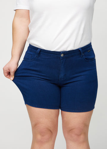 Plus size-modellen drar ut shortsen vid låret för att visa stretchen.