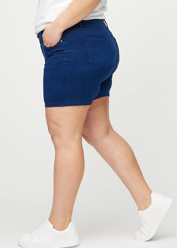 Mörkblå skinny short shorts sedda från sidan på en plus size-modell.