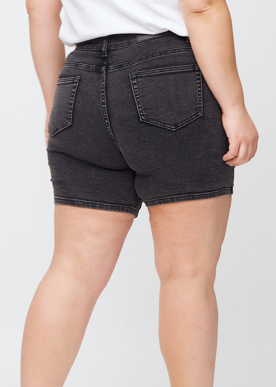 Mörkgrå denim skinny short shorts sedda bakifrån i närbild på en plus size-modell för att visa detaljer.