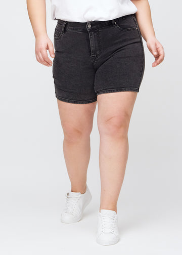 Mörkgrå denim skinny short shorts, modellnamn Shadows, som sitter tajt och slutar mitt på låret på en plus size-modell, framifrån.