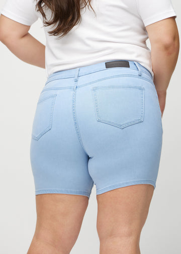  Ljusblå skinny short shorts sedda bakifrån i närbild på en plus size-modell för att visa detaljer.
