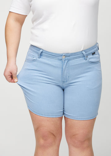 Plus size-modellen sträcker ut shortsen vid låret för att visa stretch.