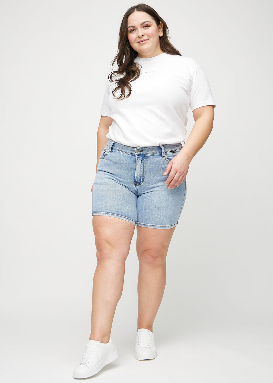 Helbild av en plus size-modell i ljus denim skinny short shorts.
