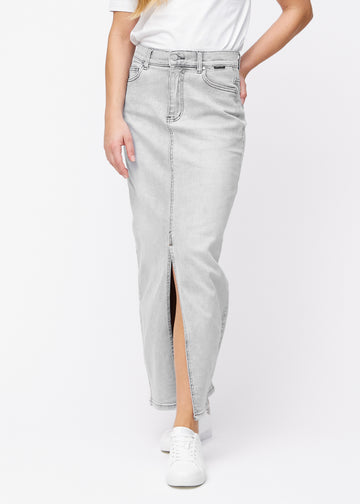 Lång ljusgrå denimkjol för kvinnor i färgen Ashes. Framifrån på en modell, med rakt fall från höfterna och en slits framtill som börjar strax under knät.