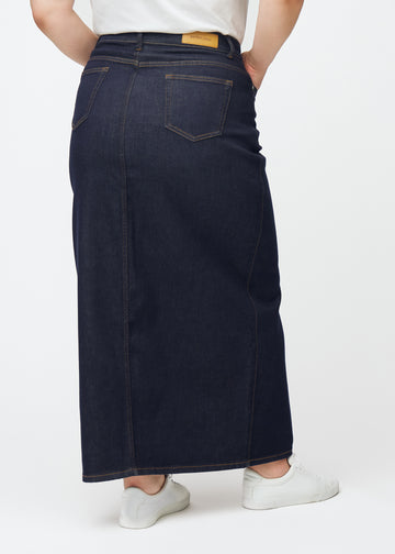Lång mörkblå denimkjol för dam i färgen Midnights sett bakifrån på plus-size modell, där hela längden syns.