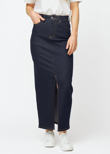 Lång mörkblå denimkjol för dam i färgen Midnights som sitter vid höften och faller rakt ner till anklarna, med slits framtill som börjar strax under knät, sett framifrån.