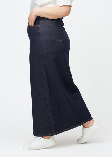Lång mörkblå denimkjol för dam i färgen Midnights sett från sidan på plus-size modell, med synlig slits framtill.