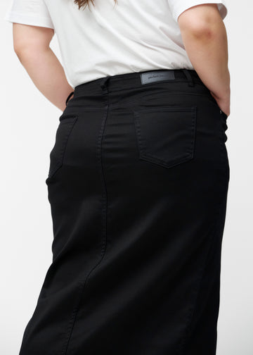Lang, sort jeansnederdel i farven Ravens set bagfra tæt på på plus-size model for at vise pasform og detaljer.