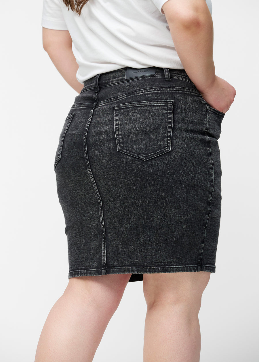 Mørkegrå, tætsiddende og knælang denimnederdel set bagfra tæt på på plus-size model for at vise detaljer.