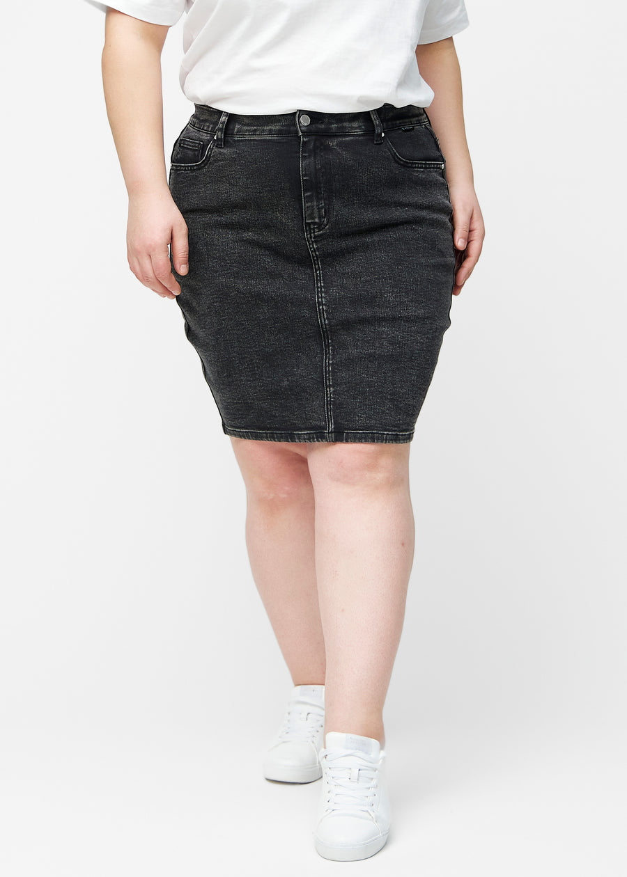 Mørkegrå, tætsiddende og knælang denimnederdel set forfra på plus-size model.