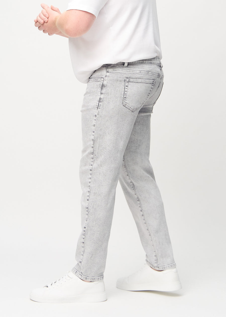 Ljusgrå denim regular jeans sedd från sidan på en plus size-modell.